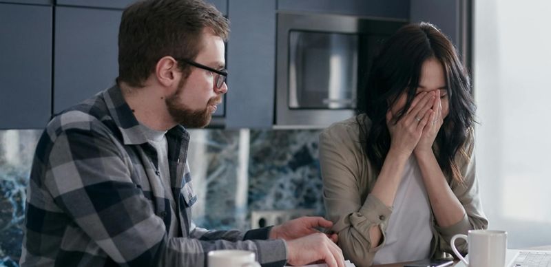 Молодой человек успокаивает плачущую девушку