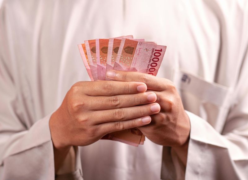 Человек держит денежные купюры