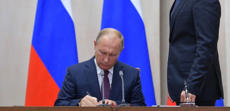Владимир Путин подписывает документ