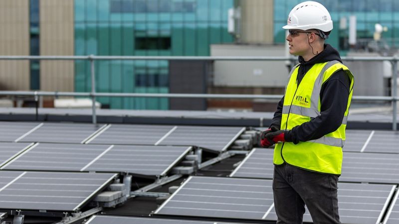 Рабочий на фоне солнечных панелей