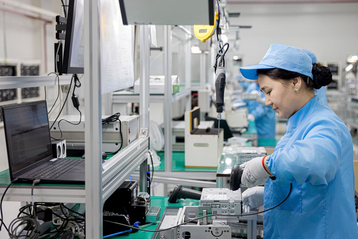 Сотрудница в униформе проверяет мульмедийную систему