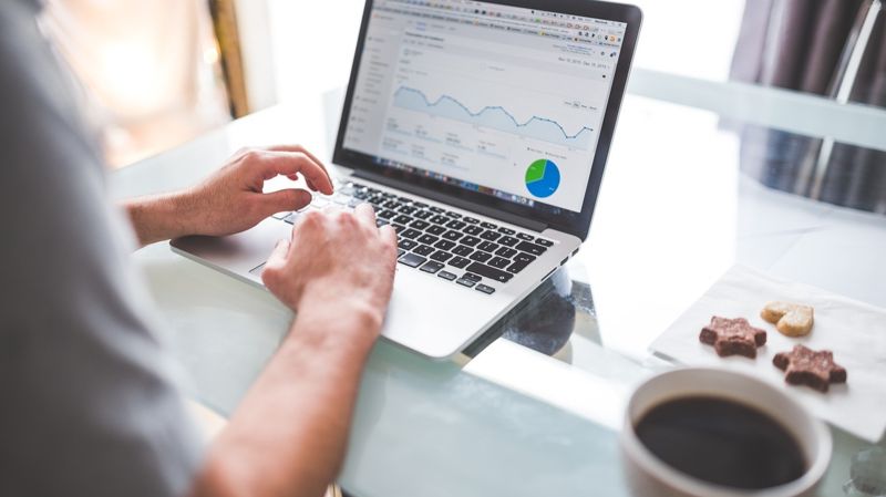 Руки у ноутбука с графиками, аналитика, прогнозы по экономике, бирже