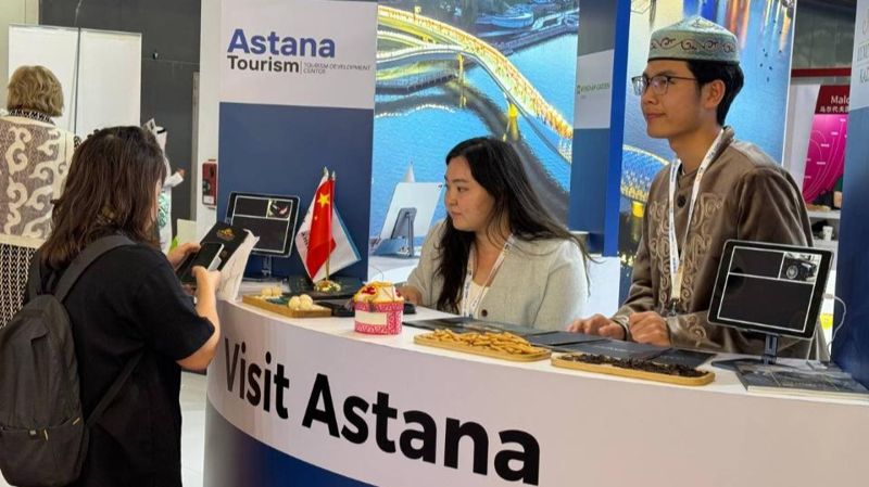 Турист стоит возле стойки визит-центра Астана, въездной туризм в Казахстане
