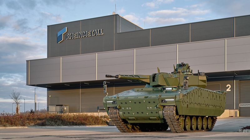 Здание с вывеской Rheinmetall и военная бронемашина перед ним.