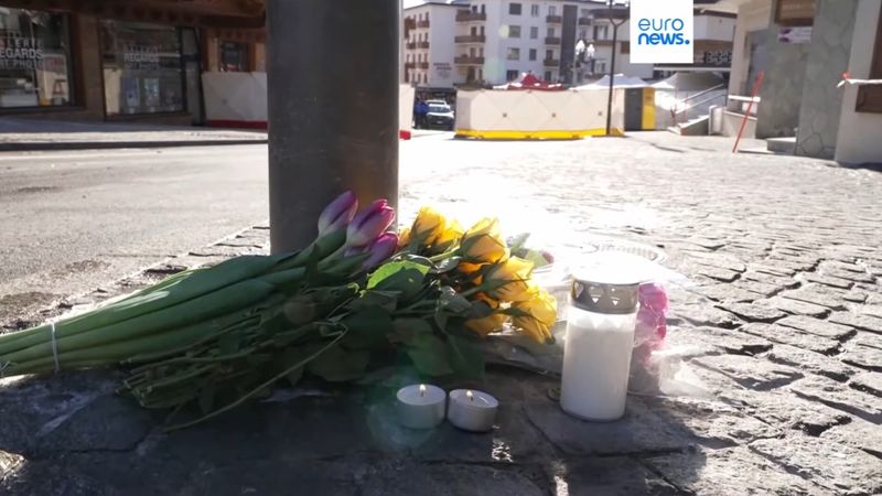 Цветы и свеча на месте пожара в Швейцарии, 2 января 2025