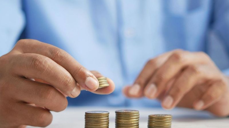 Мужчина складывает монеты в столбики