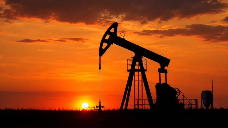 Силуэт нефтяной качалки на фоне заката 