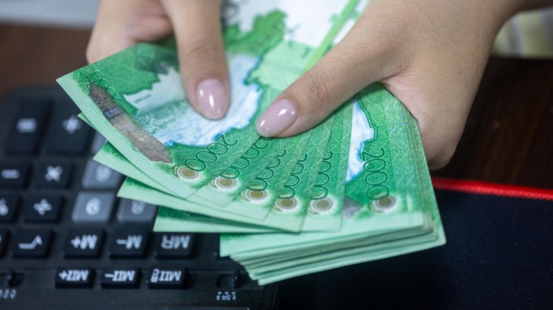 Деньги тенге в женских руках