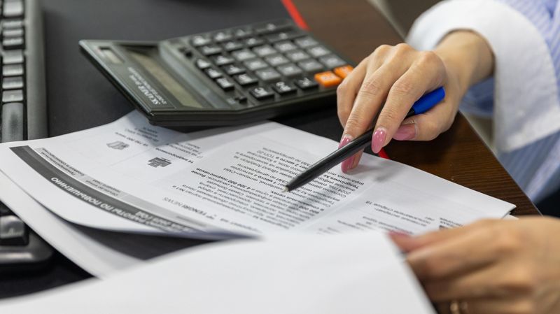 Женские руки изучают кредитные документы 